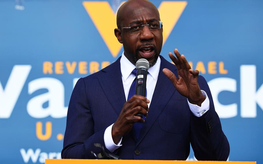 Sen. Raphael Warnock, shown campaigning in January 2021, tested positive for COVID-19 in April 2022, along with Sen. Susan Collins and others. 