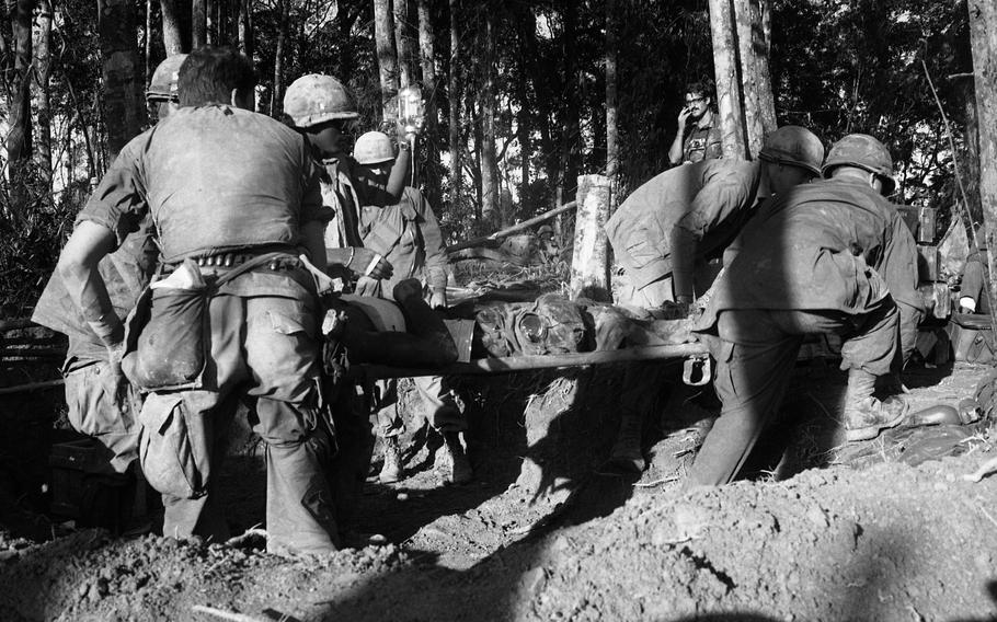Troops carry a wounded soldier on a stretcher.