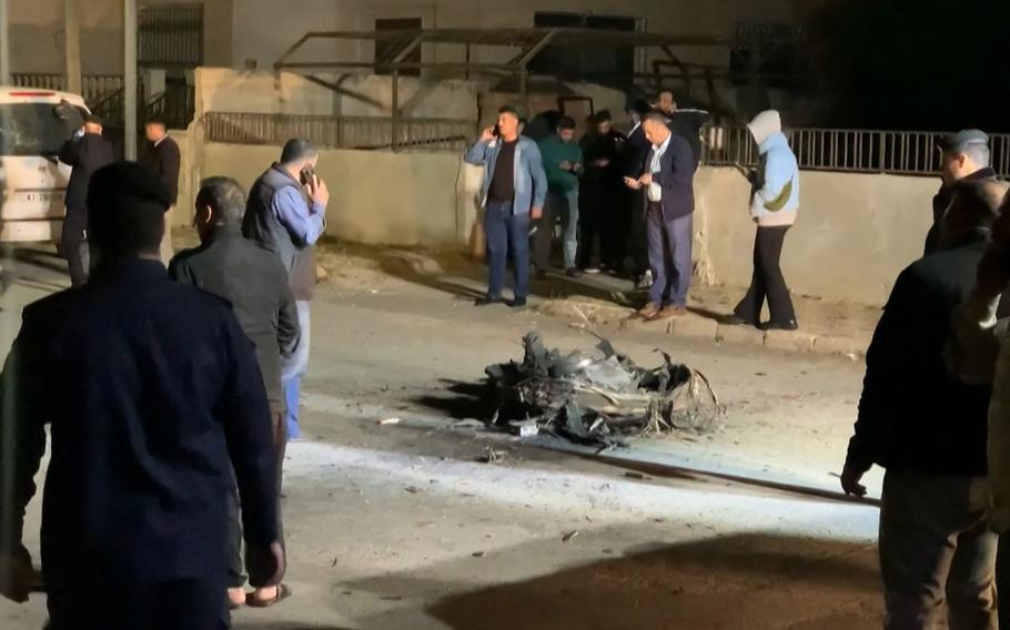An image grab from AFPTV footage shows onlookers and security agents standing around the debris of a missile that Jordanian forces intercepted over Amman amid an unprecedented Iranian drone and missile attack on Israel in the early hours of April 14, 2024. 