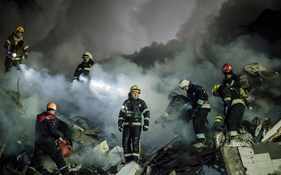 Rescuers work to free victims from the rubble of a residential apartment complex that was hit by Russian forces in Dnipro, Ukraine, on January 14, 2023. Several people were killed and more than 25 were injured, including children. The attack marked the most significant strike on the central Ukrainian city since the war began. Dnipro had until now served as a safe haven for thousands of displaced people from other regions. 