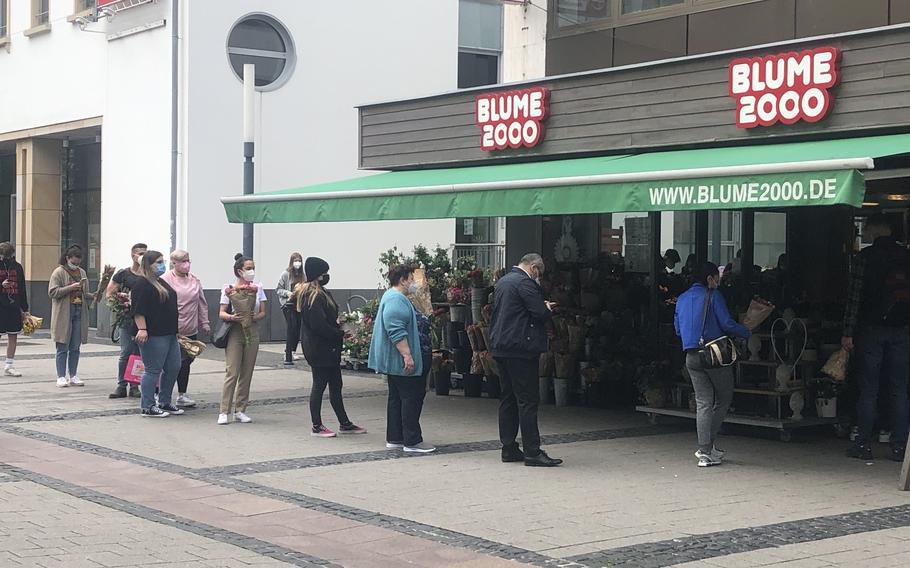 A line forms outside a flower shop in Kaiserslautern in May 2021, when strict coronavirus restrictions were in place. Many restrictions were lifted in the city and district as infections fell, but German officials reimposed some measures on July 25 as the caseload rose again.