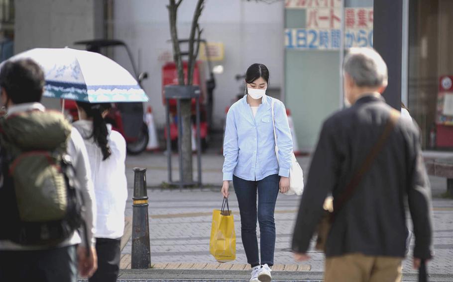 Pedestrians wear masks to guard against the coronavirus earlier this month in Zushi, Japan. 