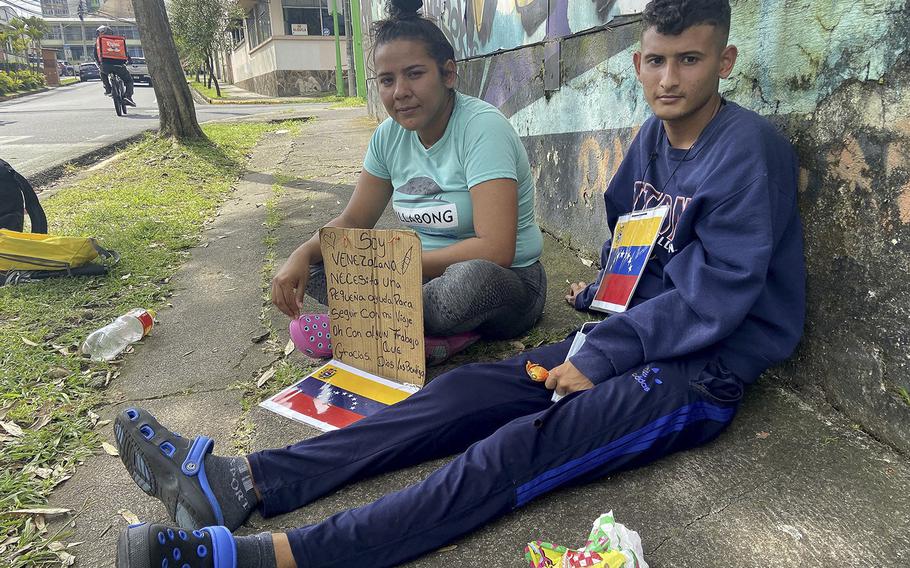 Yulexny Gonzalez, left, and Rolando Suarez left Venezuela on Aug. 20, 2022, crossed the Darien Gap and are now stuck in Costa Rica. They are selling lollipops on the streets of San Jose, Costa Rica to earn enough money for rent and basic goods. 