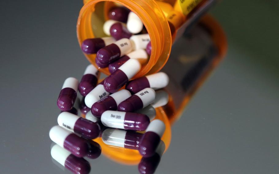 Pills pour out of a bottle.