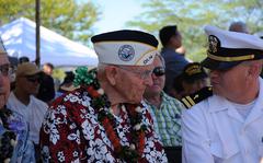 Lt. Colby Torres (right), a Chaplin at Marine Corps Base Hawaii, visits with Marine Corps Maj. John Hughes (retired) at the Ewa Battlefield Commemoration on Dec. 6, 2016. Hughes is a survivor of the attacks that took place at Ewa Field on Dec. 7, 1941.