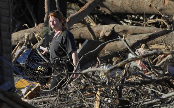 A Rolling Fork, Miss., resident walks through fallen trees as she attempts to salvage personal items following a tornado the night before that heavily damaged the Mississippi Delta community, Saturday, March 25, 2023. (AP Photo/Rogelio V. Solis)