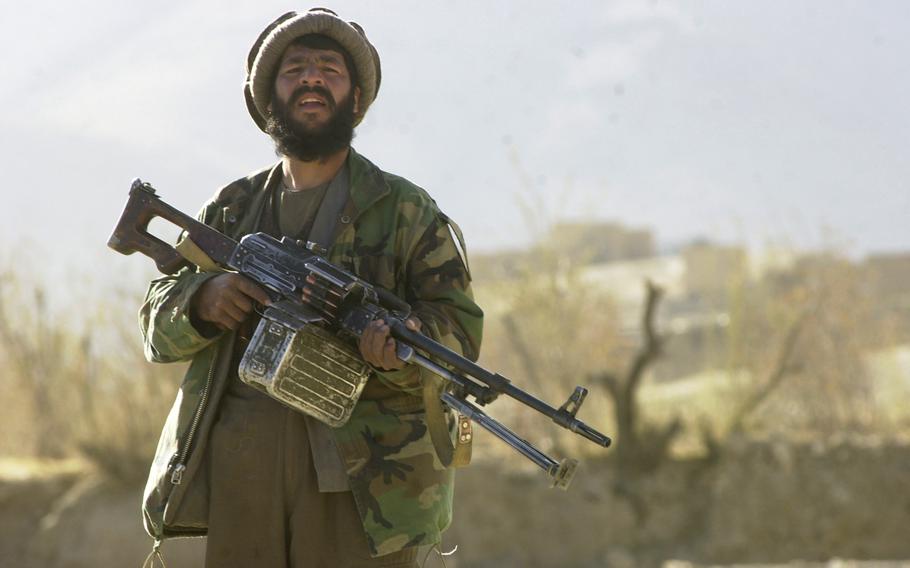  A Northern Alliance fighter watches Taliban forces leave an area around Jalreez [Jalrez] as opposition forces pushed towards the village on Nov. 24, 2001.