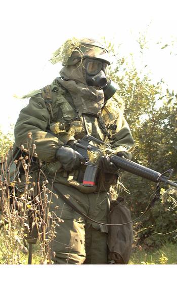 A soldier wearing a gas mask carried a rifle.