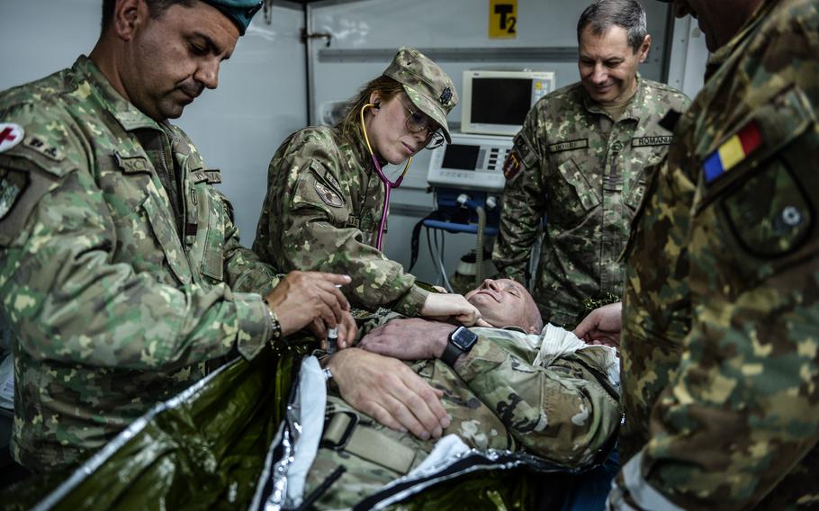 Romanian army medical technicians treat mock injuries on U.S. Army Brig. Gen. Clinton Murray near Bordusani, Romania, on June 6, 2023. Murray played the victim of severe combat trauma.