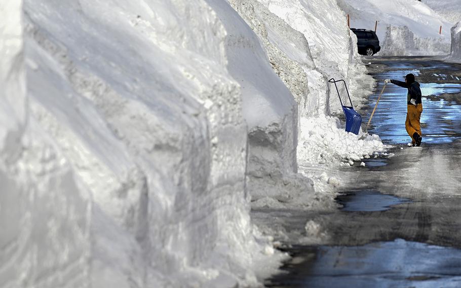 A resident takes a break from shoveling snow on March 7, 2023, in Mammoth Lakes, California. 