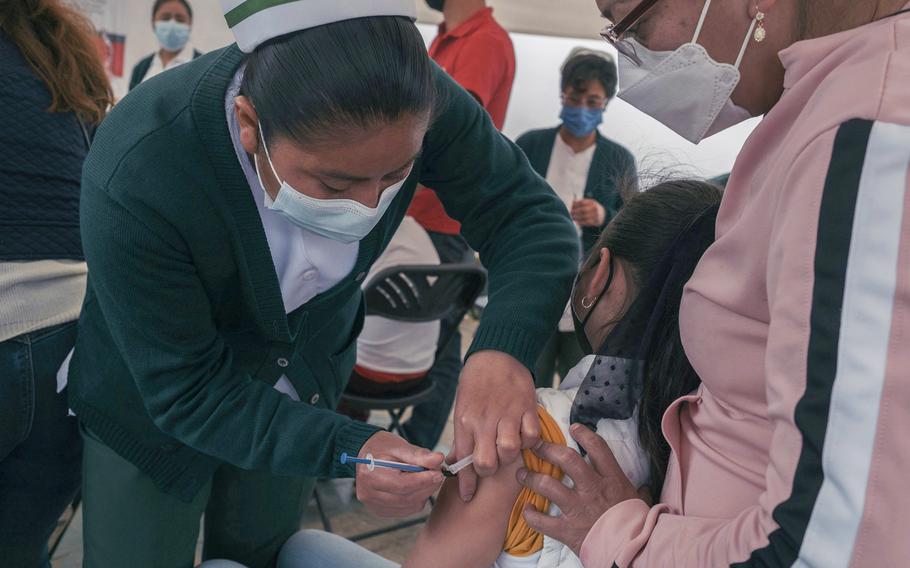 A healthcare worker administers a dose of the Pfizer-BioNTech Covid-19 vaccine to a child at a vaccination clinic for children 5-11 years old in San Cristobal de las Casas, Chiapas state, Mexico, on June 30, 2022. 