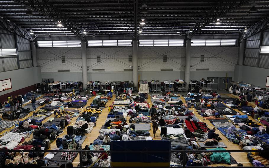 Ukrainian refugees wait in a gymnasium Tuesday, April 5, 2022, in Tijuana, Mexico. As many as 20,000 Ukrainians who were granted permission to remain in the United States for one year after fleeing the early fighting in their native country are facing their humanitarian parole expiring, according to advocates.