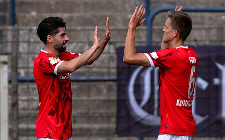 Two soccer players high five.