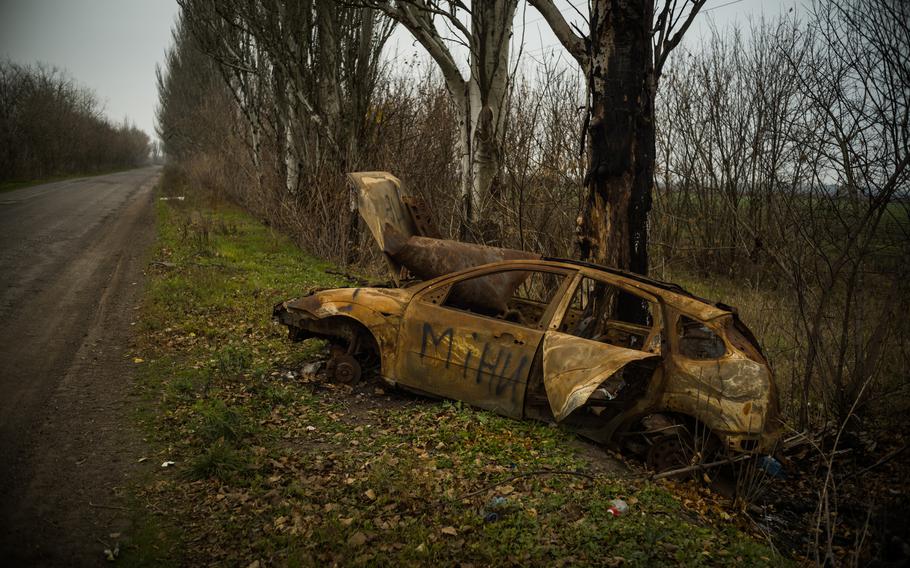 A burned car marked with the warning “mines” sits along the road to Zelenyi Hai village, Ukraine, in November. 