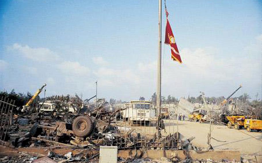 The Marine Corps colors fly over a mound of debris left after a terrorist attack at the Marine barracks in Beirut, Lebanon, Oct. 23, 1983. A suicide bomber driving a truck rammed into the barracks with 12,000 pounds of high explosives, detonating one of the largest non-nuclear bombs in history.
