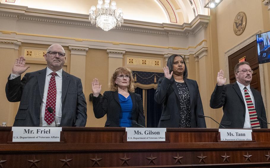 Four people standing and raising their right hands.