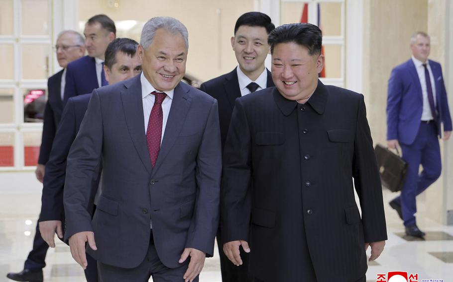 North Korean leader Kim Jong Un walks beside a Russian defense official.