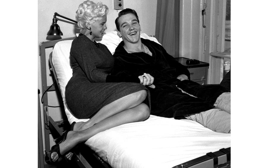 Jayne Mansfield climbs onto the hospital bed of one lucky soldier while visiting the wards of the Army’s 97th General Hospital in Frankfurt, Germany Oct. 5, 1957. The photographer identified the patient as Leary (last name only).