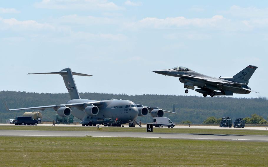 A U.S. Air Force F-16 from the 52nd Fighter Wing takes off past a C-17 cargo plane June 14, 2023, at Spangdahlem Air Base, Germany. The F-16 was taking part in the German-led NATO exercise Air Defender 23.