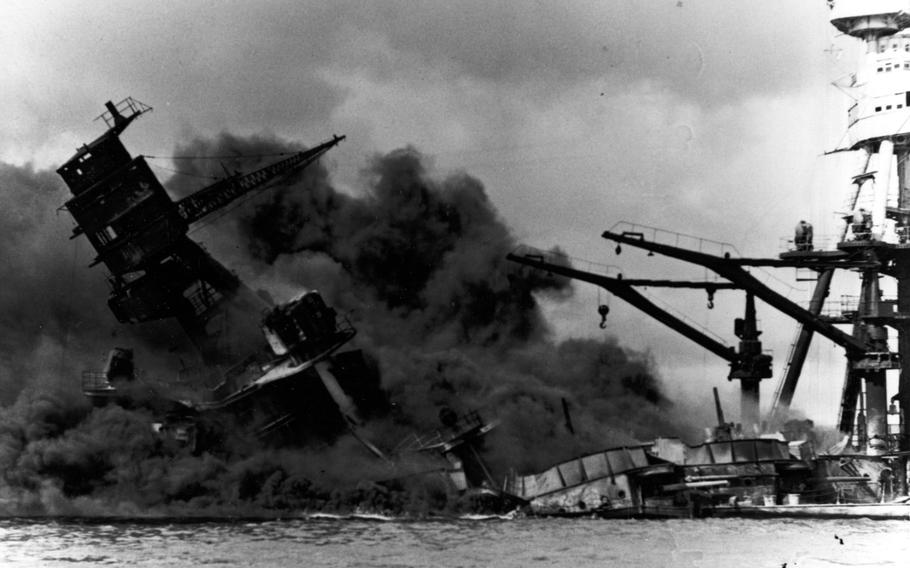 The USS Arizona engulfed in flames and smoke, listing to the starboard side and sinking.