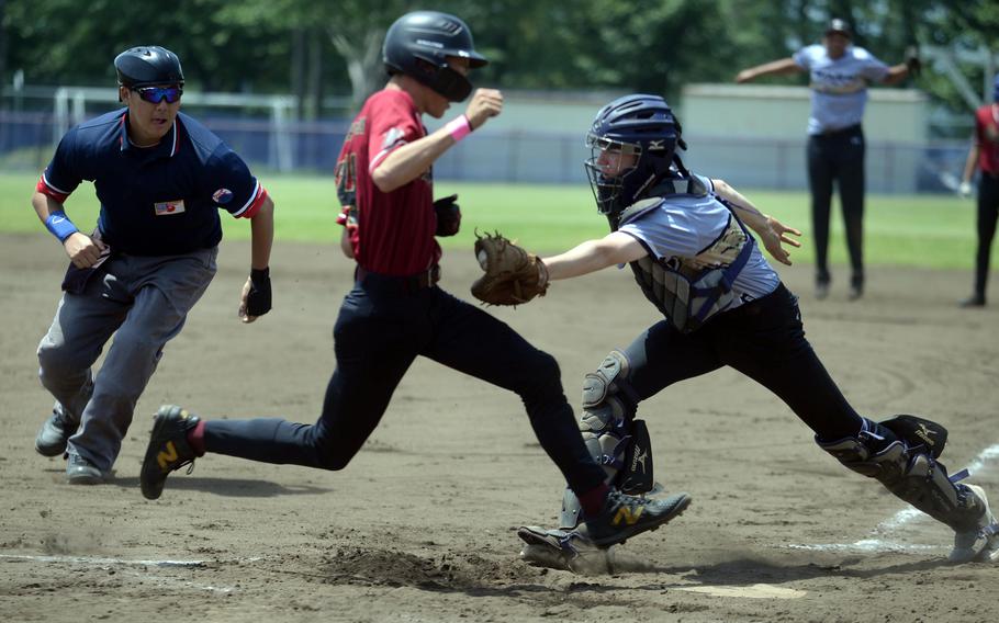 Zama catcher Sean Hughes readses the tag on Perry baserunner Taisei Shimakura as umpire Michitaka Akisato eyes the action.