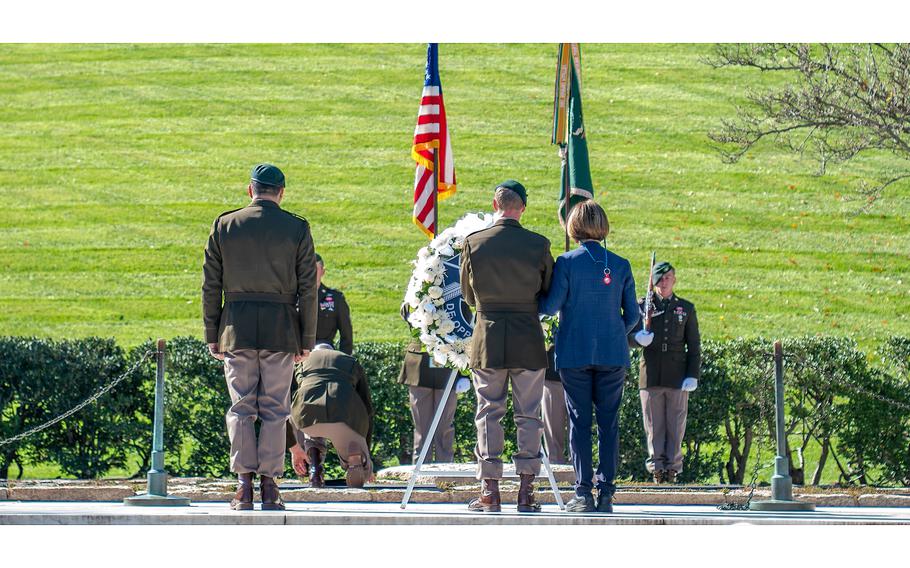 Command Sgt. Maj. David Waldo, the senior enlisted leader of the 1st Special Forces Command, kneels as he places his beret on the pavement at the gravesite of former President John F. Kennedy during a wreath-laying ceremony at Arlington National Cemetery on Wednesday, Nov. 8, 2023.