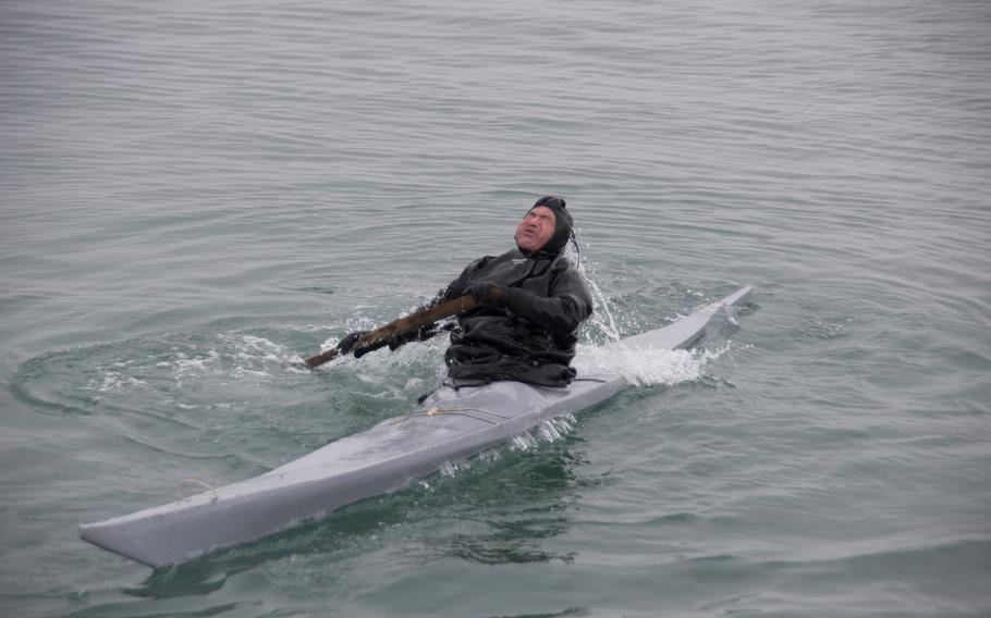 Outdlaq Qujaukitsoq comes up for air while demonstrating how to roll his kayak in front of a small but appreciative and apprehensive crowd watching from the Thule Air Base main pier.