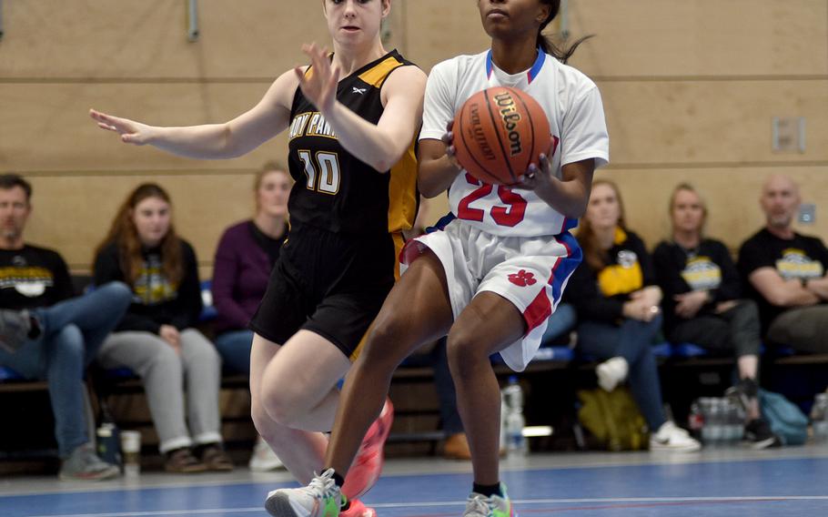 Ramstein's Bralyn Jones picks up the ball while driving to the hoop as Stuttgart's Bella Henderson defends during round-robin action at the Division I DODEA European Basketball Championships on Friday morning at Ramstein High School on Ramstein Air Base, Germany. The Royals defeated the Panthers, 34-28.
