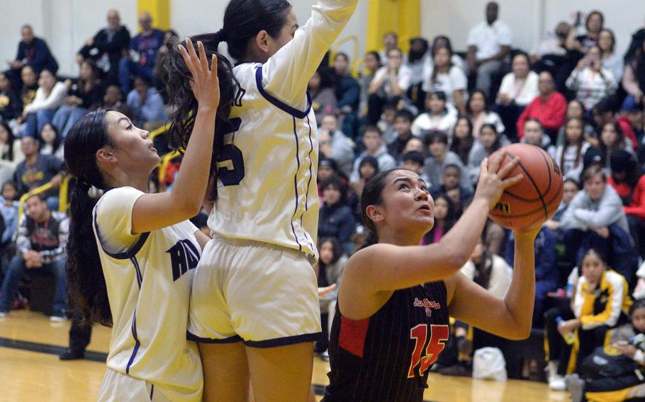 Kinnick's Leona Turner tries to shoot past Academy's Maddia Ada and Maria Paulino.