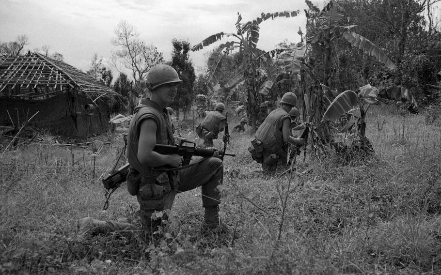 Marines take cover to fight off an ambush by the North Vietnamese Army. A claymore mine explosion minutes earlier cost the life of the platoon sergeant of Alpha Company, 1st Battalion, 9th Marines. 