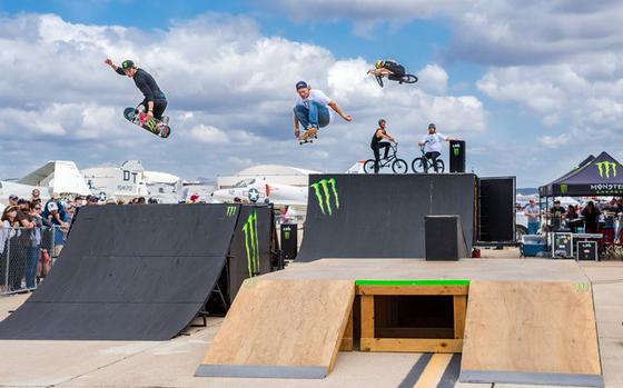 Skateboarders and bikers do stunts and tricks on a Monster Energy ramp