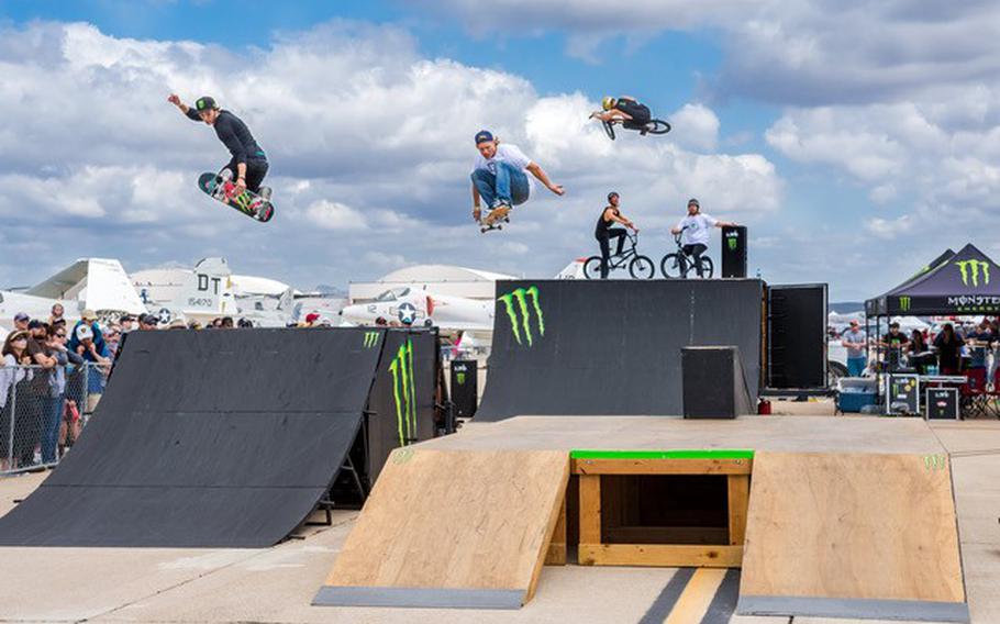 Skateboarders and bikers do stunts and tricks on a Monster Energy ramp