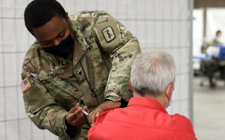 Spc. Torrin King administers a Johnson & Johnson COVID-19 vaccine in May 2021 at Rhine Ordnance Barracks in Kaiserslautern, Germany. Germany’s health minister has backed off a decision to end obligatory isolation for people who test positive for COVID-19.