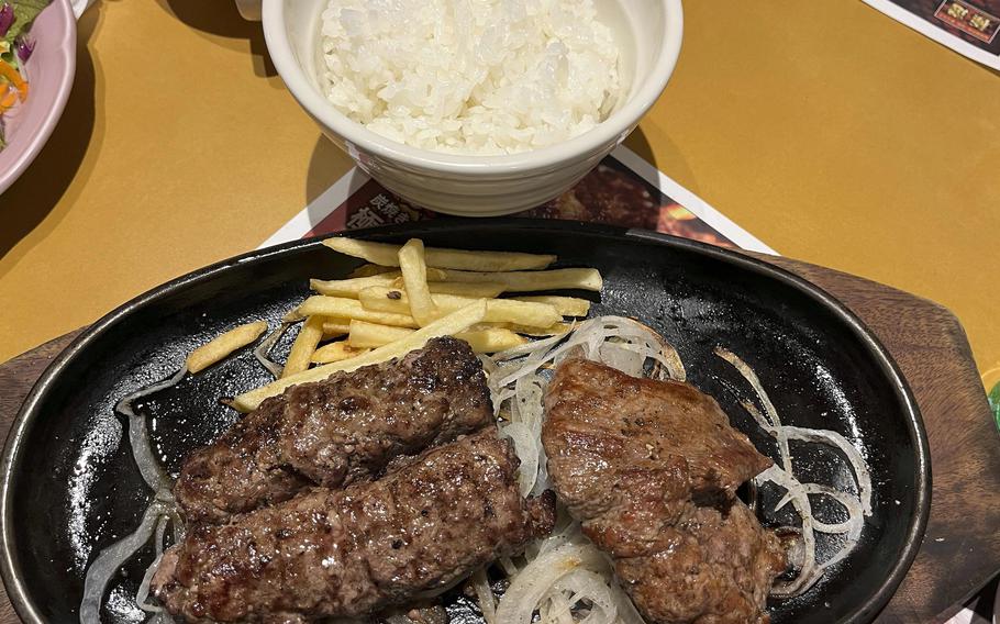 Steaks and hamburgers are cooked on a blazing charcoal-flame grill near the front of Bronco Billy Steak House.