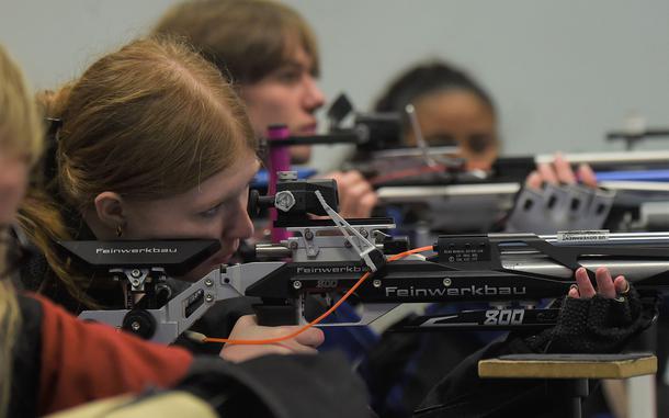 Shooters sight in during their prep time for the kneeling event of the marksmanship competition at the JROTC air rifle range inside Vilseck High School, Vilseck, Germany, on Saturday, Dec. 3, 2022.
