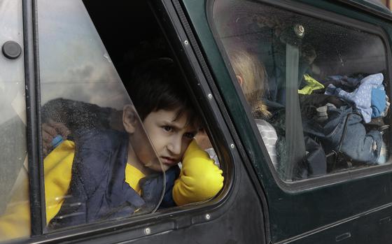 An ethnic Armenian boy from Nagorno-Karabakh, looks on from a car upon arrival in Armenia's Goris, the town in Syunik region, Armenia, Monday, Sept. 25, 2023. Thousands of Armenians have streamed out of Nagorno-Karabakh after the Azerbaijani military reclaimed full control of the breakaway region last week. (AP Photo/Vasily Krestyaninov)