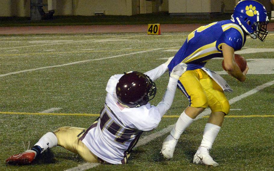 Matthew C. Perry's Denzel Gray gets two fistfuls of Yokota quarterback Dylan Tomas' jersey.