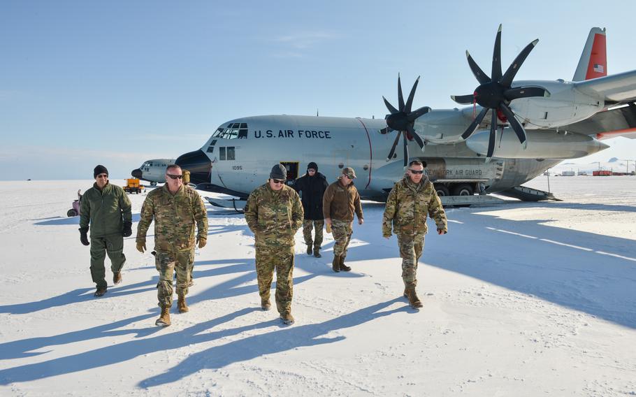 U.S. Air Force Gen. Ken Wilsbach, back left, Pacific Air Forces commander; Chief Master Sgt. David Wolfe, front left, PACAF command chief; and other PACAF representatives meet with Joint Task Force-Support Forces Antarctica (JTF-SFA) personnel next to an LC-130 at Williams Field, a compacted snow ice runway at McMurdo Station, Antarctica, Feb. 4, 2023. 