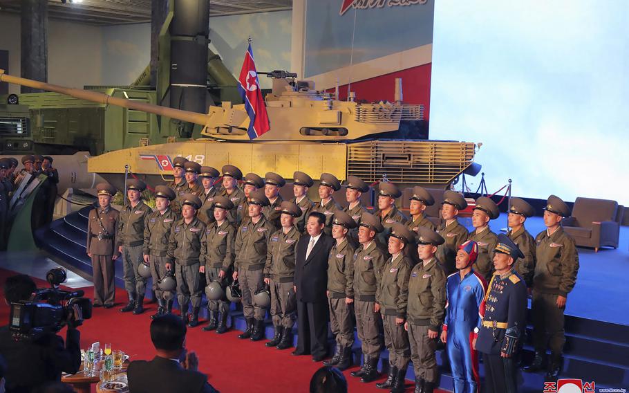 North Korean leader Kim Jong Un, center, poses for a group photo with fighter pilots who made the demonstration flight at the opening of an exhibition of weapons systems in Pyongyang, North Korea, Monday, Oct. 11, 2021. 