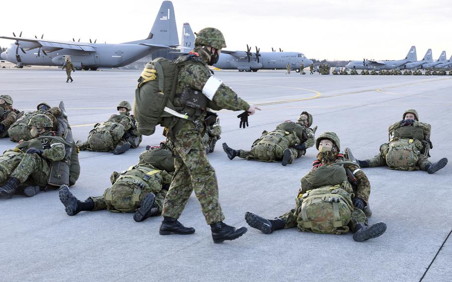 Paratroopers from the Japan Ground Self-Defense Force prepare their gear at Yokota Air Base, Japan, Tuesday, Jan. 31, 2023.