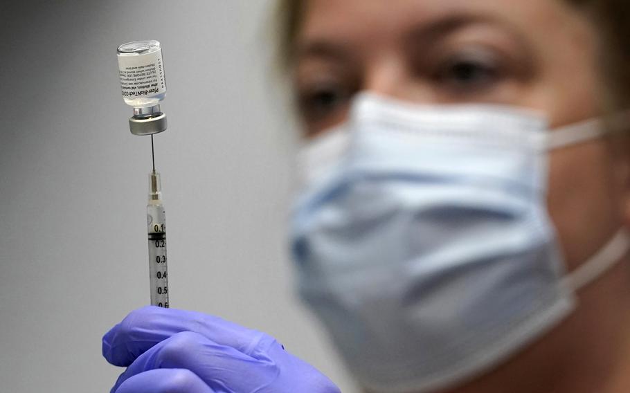 In this March 2, 2021, file photo, Hollie Maloney, a pharmacy technician, loads a syringe with Pfizer's COVID-19 vaccine at the Portland Expo in Portland, Maine. 