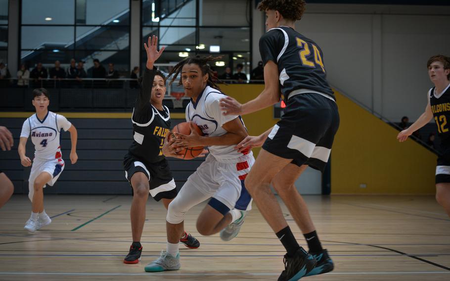 Aviano’s Deon Walker slaloms around Bahrain’s Petros Hilawe, left, and Ouael Fartas during the DODEA-Europe Division II boys basketball tournament Wednesday, Feb. 15, 2023, at Ramstein Air Base, Germany.