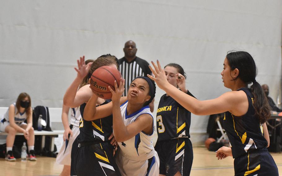 Hohenfels' Kariana Jones splits two Ansbach defenders while heading toward the basket Friday, Feb. 25, 20222 at the DODEA-Europe basketball championships.