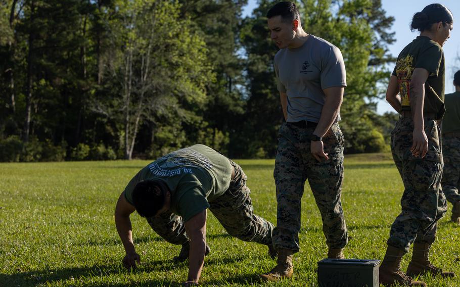 An instructor motivates a Marine during a physical training event