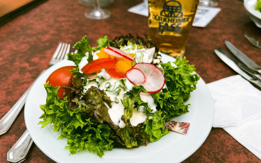 This salad is served in traditional German style, with servings of julienned carrots and coleslaw hidden underneath leafy greens, peppers, onions and radishes. 