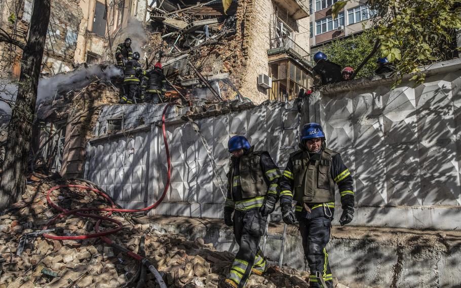 Firefighters at a residential building that was struck during a Russian attack using kamikaze drones that hit in central Kyiv, Ukraine, on Oct. 17, 2022. 