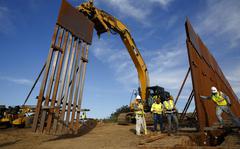 FILE - Construction crews install new border wall sections seen from Tijuana, Mexico., Jan. 9, 2019. An anti-immigration group scored a legal victory on Friday, Aug. 12, 2022, in its federal lawsuit arguing the Biden administration violated environmental law when it halted construction of the U.S. southern border wall and sought to undo other immigration policies by former President Donald Trump. (AP Photo/Gregory Bull, File)