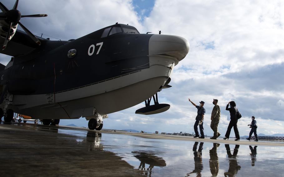 Capt. Koichi Washizawa of the Japan Maritime Self-Defense Force gives a tour of the ShinMaywa US-2 seaplane to the deputy commander of Air Force Special Operations Command, Maj. Gen. Eric Hill, at Marine Corps Air Station Iwakuni, Japan, Tuesday, Nov. 9, 2021.