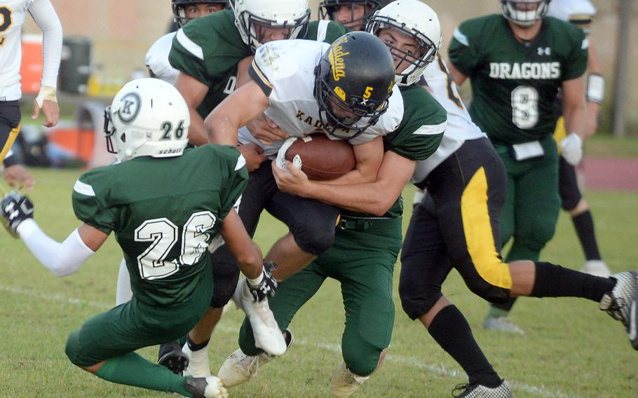 Kadena running  back Trent Fowler gets hhemmed in by Kubasaki's Jacob Acosta and Justin Podozon.