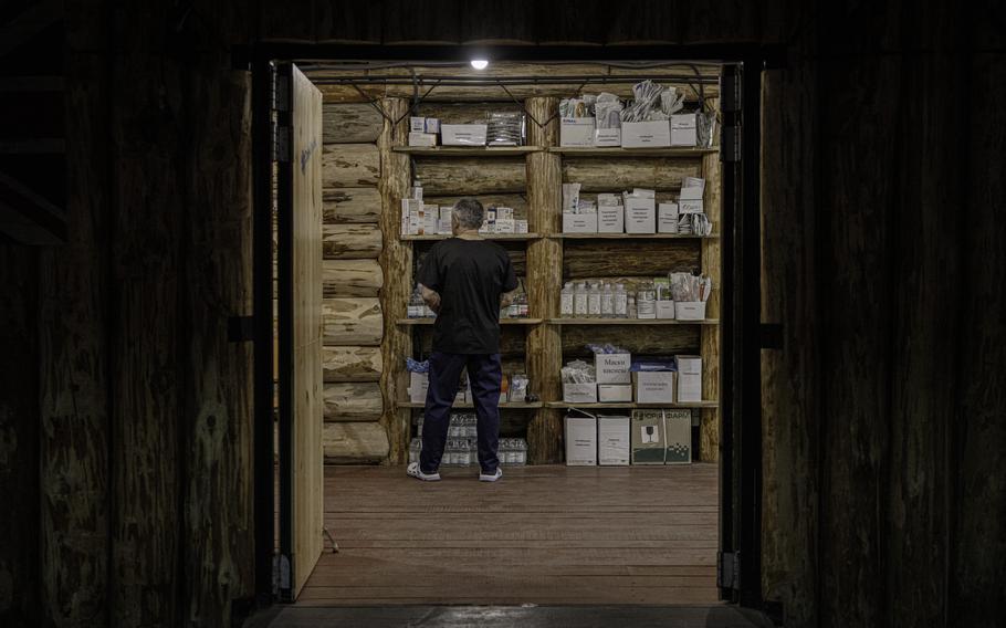 A doorway opens to some shelves filled with medication.